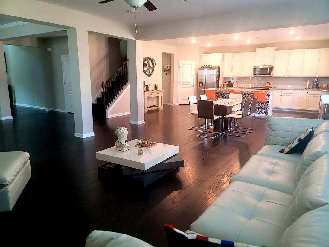 Open-plan living and dining room with dark wood flooring installed by Team A Floors